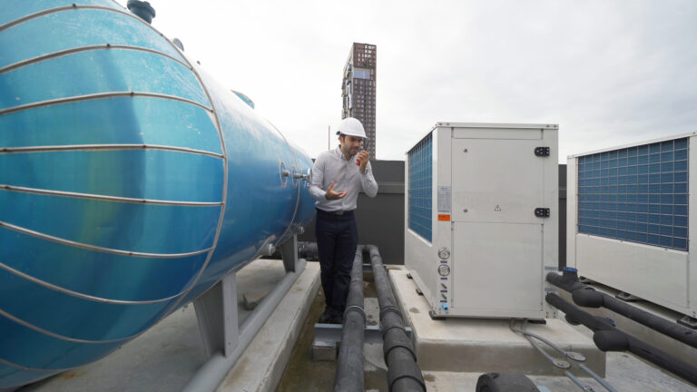 An engineer man or worker, people working in industry factory. Chiller tower on rooftop building. System work machine. Condenser Water Supply pipe lines. Ventilation compressor. Workshop site.