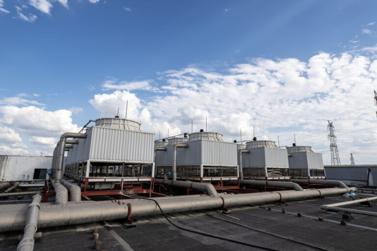 Technician inspecting cooling tower vibration issues in a commercial HVAC system